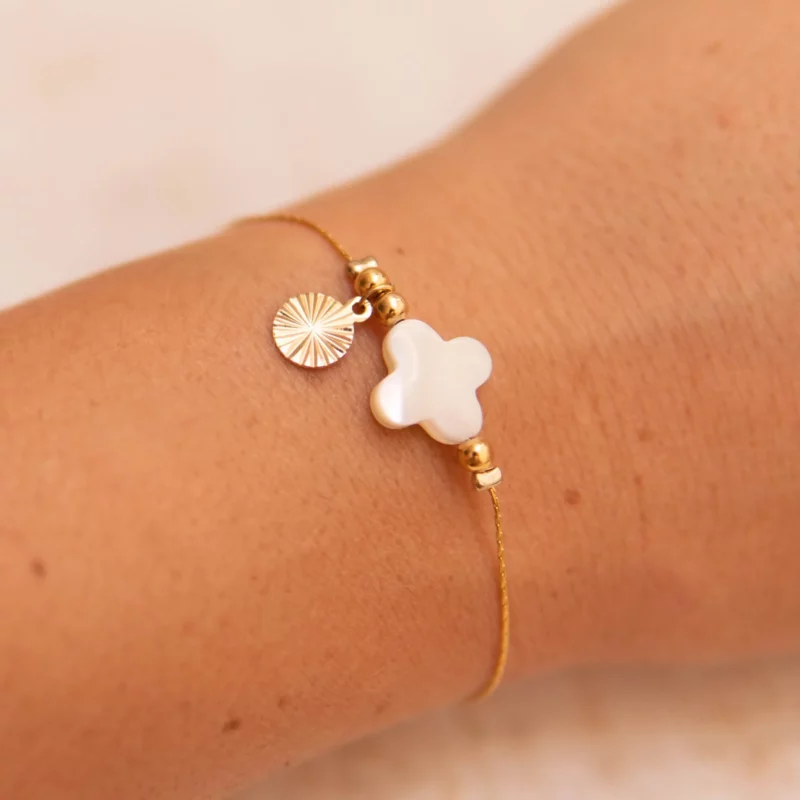 Bracelet élégant en acier inoxydable composé d’une pierre de nacre blanche naturelle en forme de trèfle , d’une chaîne plaqué or avec un petit pendentif soleil