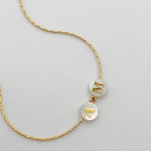 Bracelet fin et élégant en acier inoxydable doré avec deux perles de nacre lettrées. Résistant à l'eau ne noircit pas, raffiné.