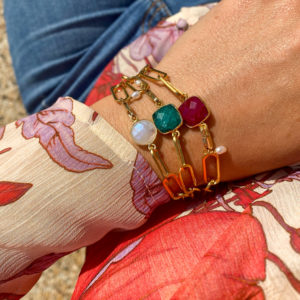Bracelet en acier inoxydable avec une chaîne doré et des pierres semi-précieuses silimanite couleur rubis, silimanite couleur émeraude, pierre de lune et d'une perle de culture