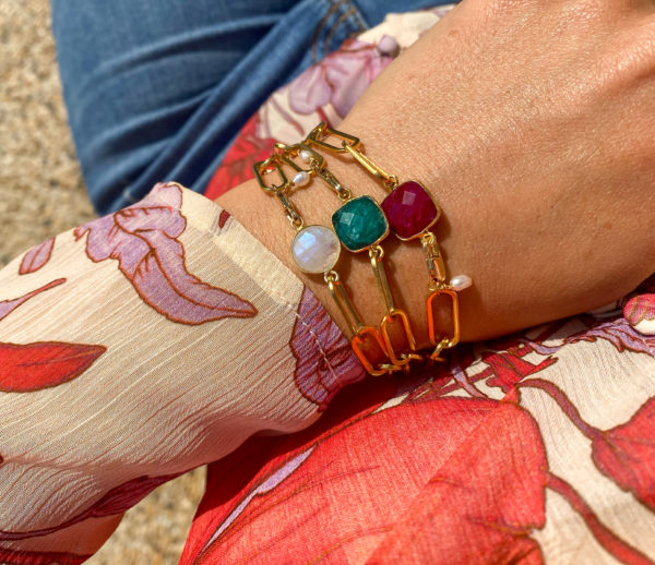 Bracelet en acier inoxydable avec une chaîne doré et des pierres semi-précieuses silimanite couleur rubis, silimanite couleur émeraude, pierre de lune et d'une perle de culture