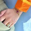 Bracelet en acier inoxydable avec une chaîne doré et des pierres semi-précieuses silimanite couleur rubis, silimanite couleur émeraude, pierre de lune et d'une perle de culture