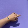 Bracelet en acier inoxydable avec une chaîne doré et des pierres semi-précieuses silimanite couleur rubis, silimanite couleur émeraude, pierre de lune et d'une perle de culture