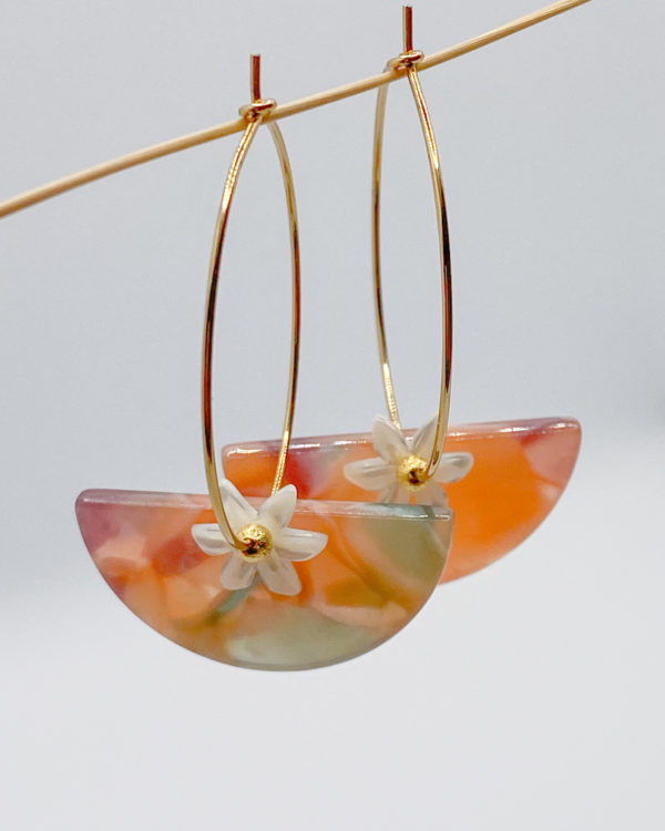 Paire de boucles d'oreilles composées de créoles, d'une demi-lune en acétate, d'une marguerite en nacre blanche. Résiste à l'eau, élégant.