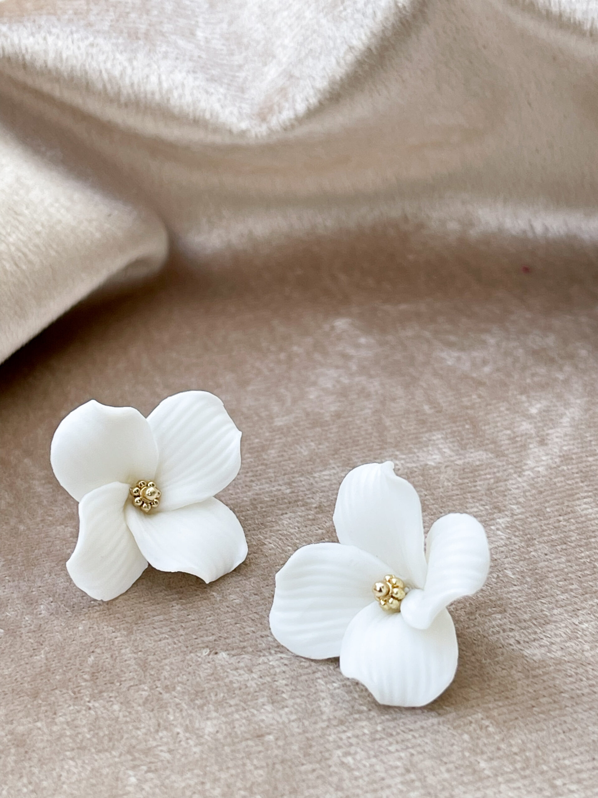 Paire de boucles d’oreilles délicates, légères en acier inoxydable composées d’un clou d’oreilles et d’une fleur en céramique blanche