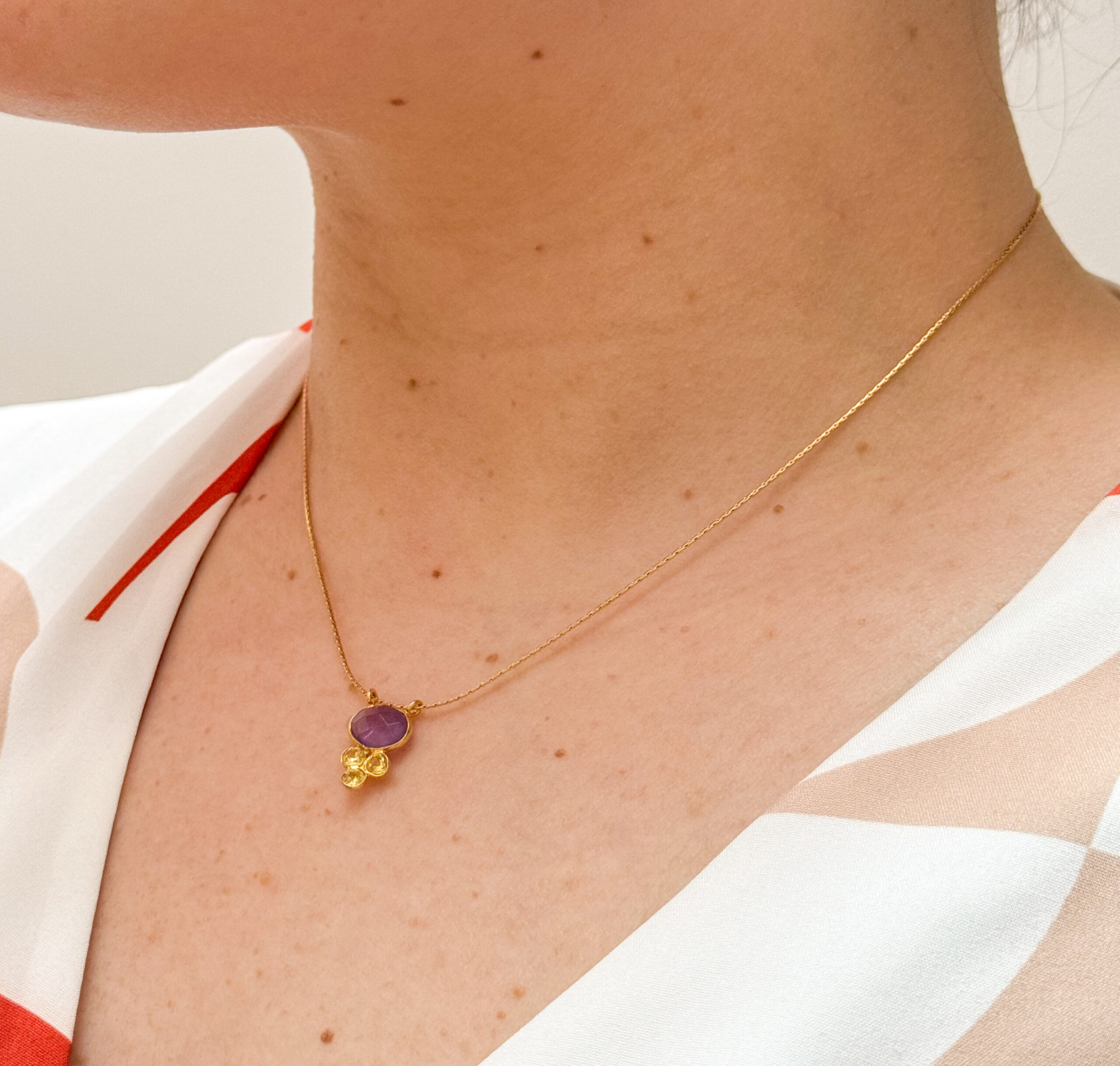 Collier court en acier inoxydable composé d’une chaine serpentine Améthyste et zircons jaune montées sur pendentif